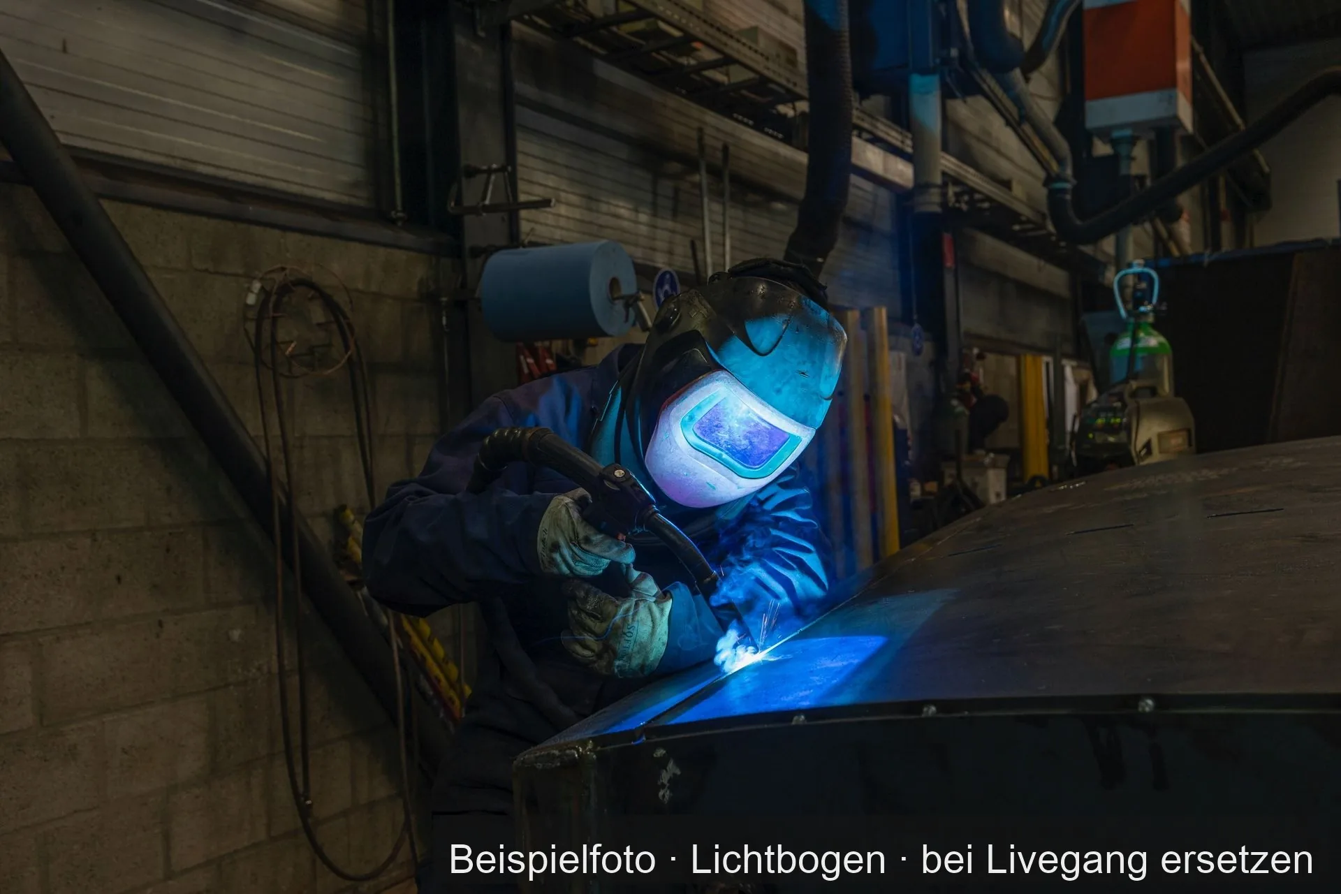Ein Schweißer schweißt an einer Blechkonstruktion in einer Metallbauwerkstatt.