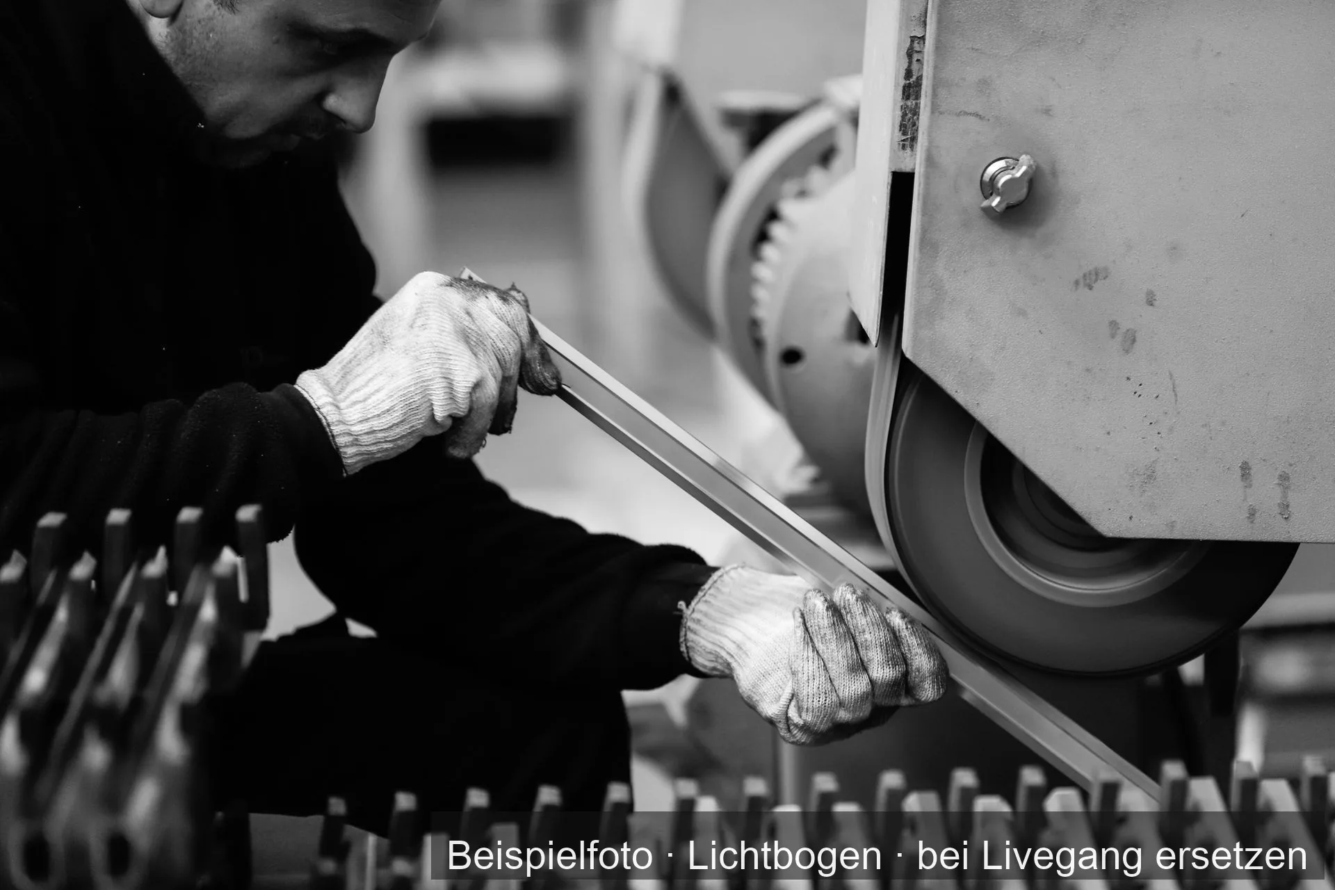 Ein Metallprofil wird an einem Bandschleifer bearbeitet.